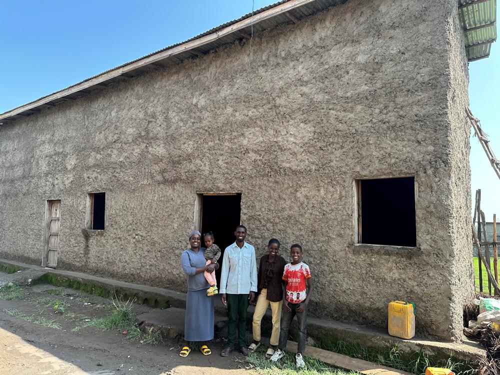 Sidama, Ethiopia family outside new safe home—Hawassa Hope Building Hope initiative providing secure housing and empowering vulnerable communities.