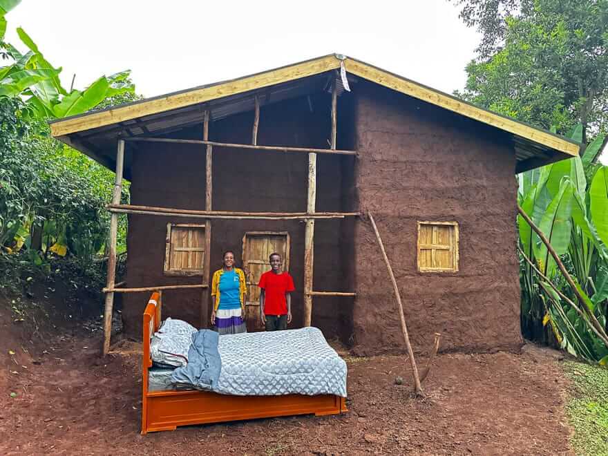 A mom and son stands in front of their newly built home by Hawassa Hope in Ethiopia